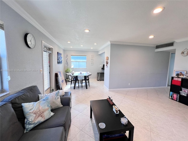 living room featuring light tile patterned floors, a textured ceiling, and ornamental molding