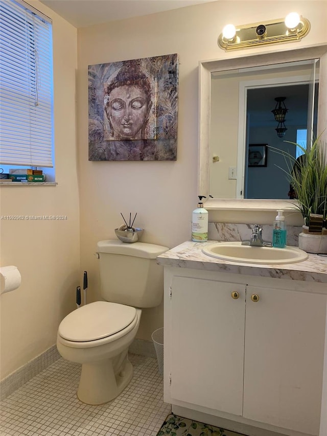 bathroom with tile flooring, vanity, and toilet