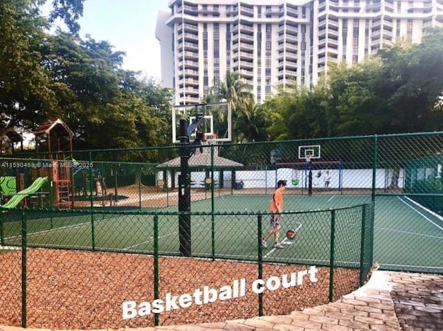 view of tennis court with a playground and basketball hoop