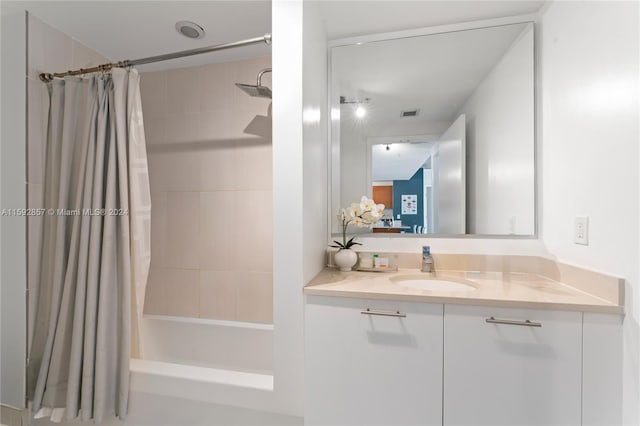 bathroom with shower / tub combo with curtain and vanity with extensive cabinet space