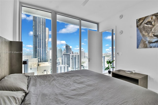 bedroom featuring multiple windows, access to outside, and floor to ceiling windows