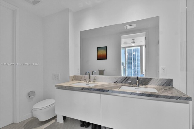 bathroom featuring dual vanity, ceiling fan, and toilet