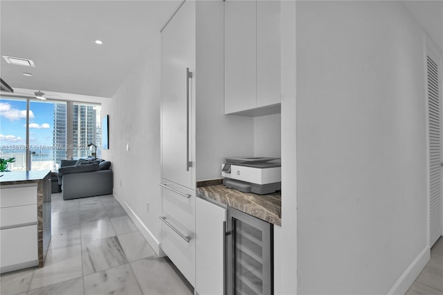 kitchen featuring white cabinetry, beverage cooler, light tile patterned floors, and ceiling fan