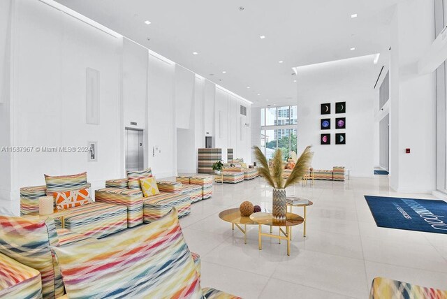 tiled living room with elevator and a high ceiling