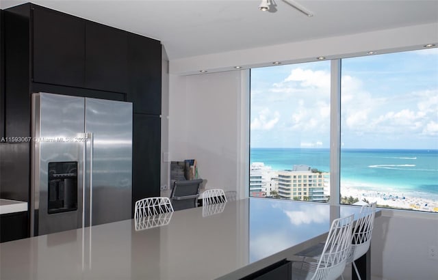 kitchen featuring a healthy amount of sunlight, a water view, and high end fridge