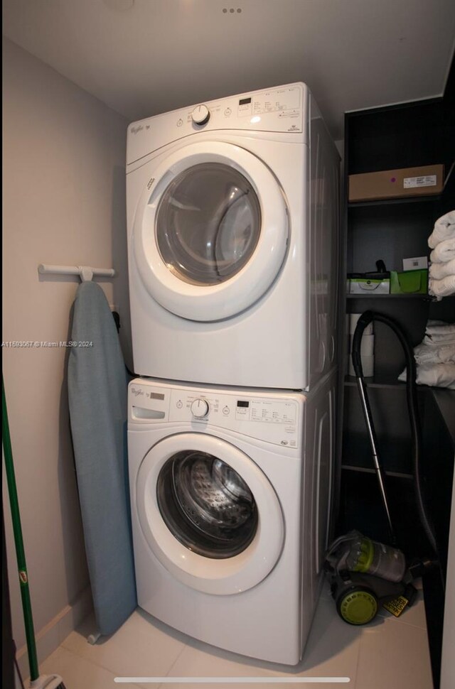 laundry area featuring tile floors and stacked washer / dryer