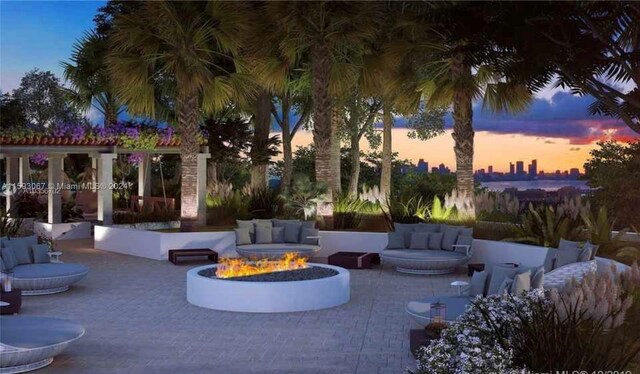 patio terrace at dusk featuring an outdoor living space with a fire pit