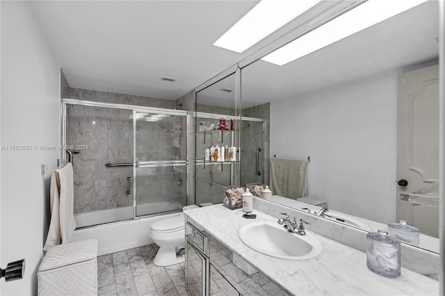 full bathroom featuring vanity, toilet, and shower / bath combination with glass door