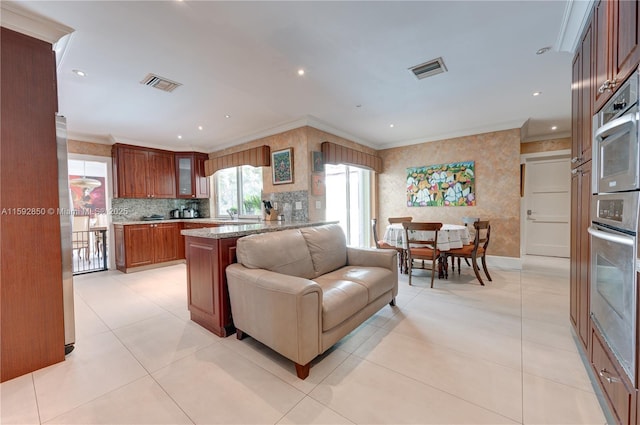 kitchen featuring ornamental molding, kitchen peninsula, and stainless steel oven