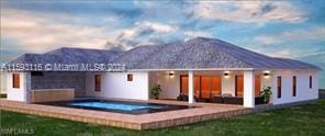 back house at dusk featuring a jacuzzi and a mountain view