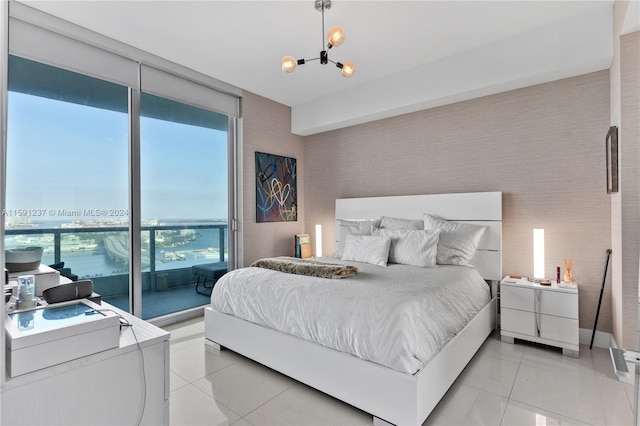 bedroom featuring a water view, access to exterior, a chandelier, and light tile floors