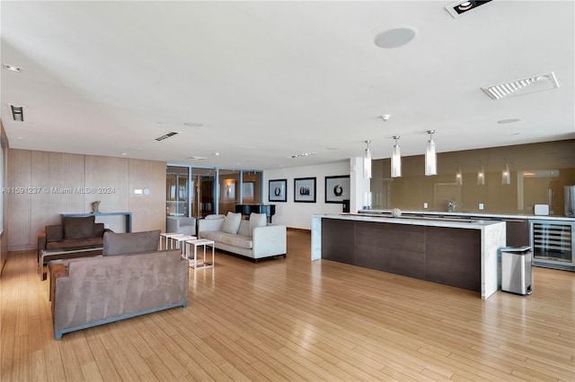 kitchen with light hardwood / wood-style floors, beverage cooler, and a kitchen island