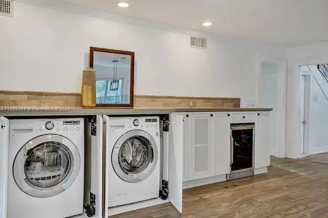 laundry room featuring washer and clothes dryer and hardwood / wood-style floors