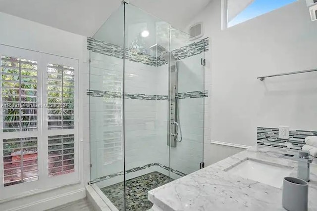 bathroom with a shower with door and lofted ceiling