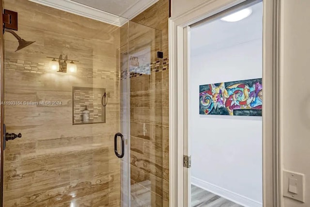 bathroom featuring a shower with shower door, hardwood / wood-style flooring, and ornamental molding