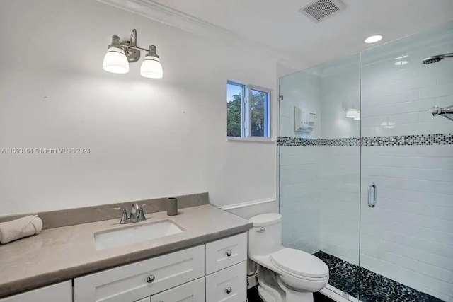 bathroom with a shower with door, vanity, and toilet