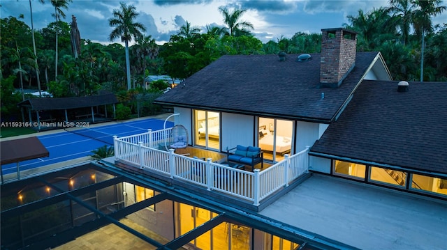 back house at dusk with a balcony