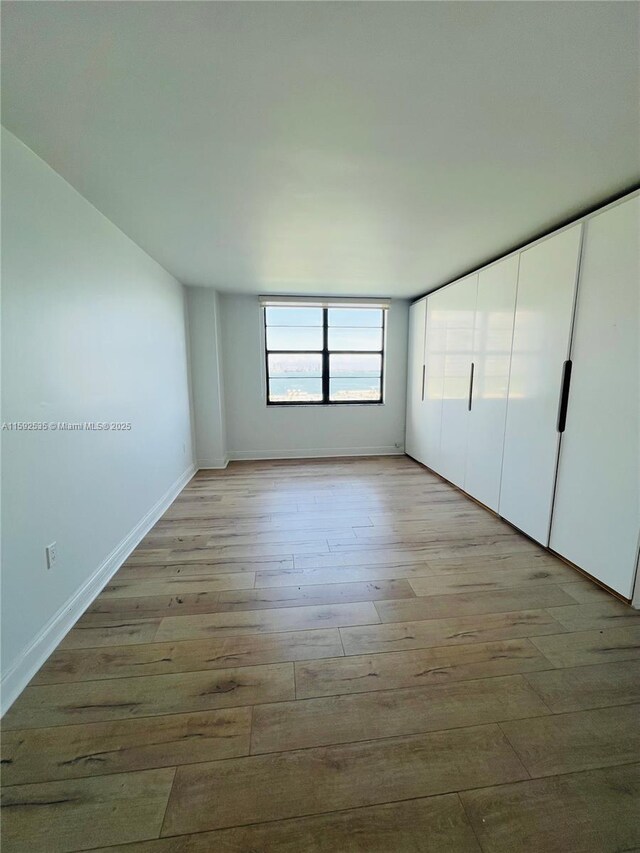 sunroom / solarium featuring a water view and a baseboard radiator