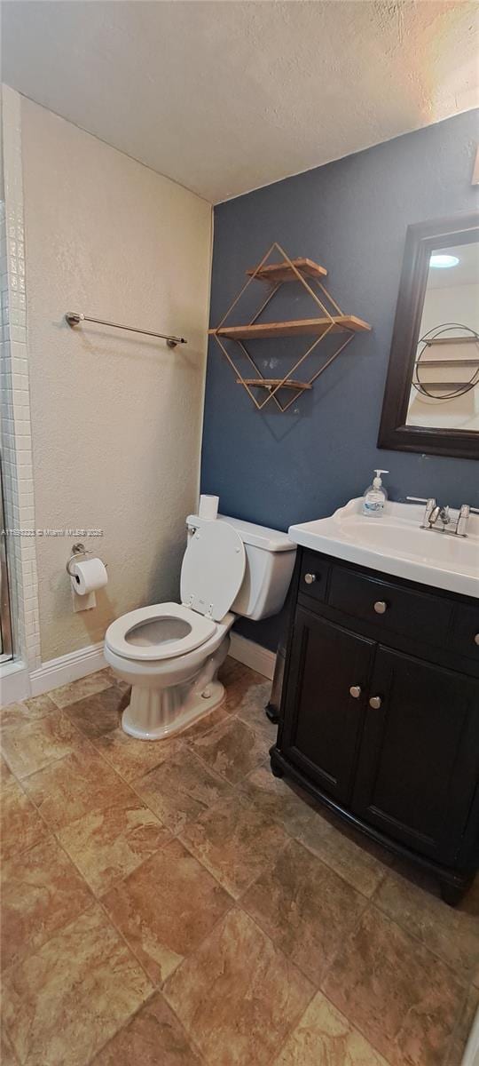 bathroom featuring vanity, an enclosed shower, and toilet