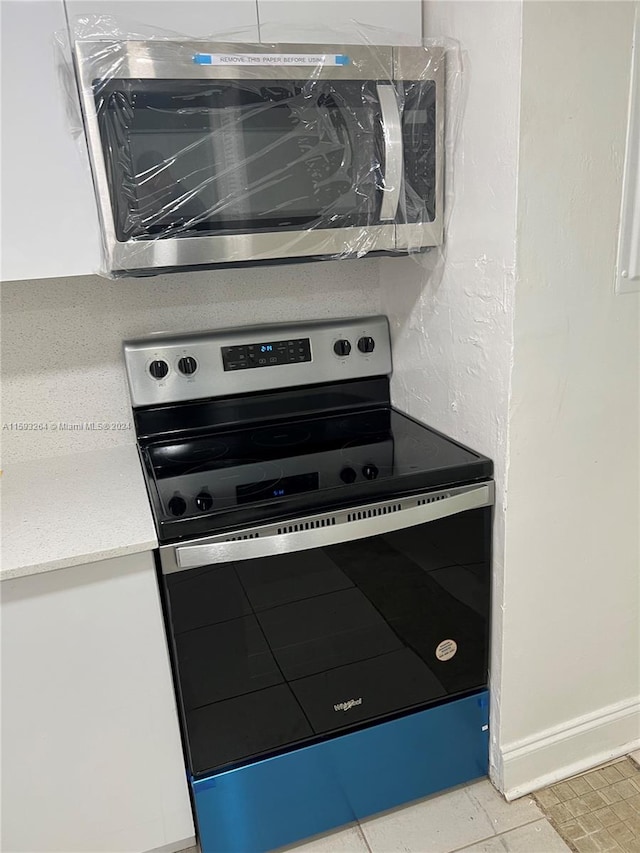 room details with appliances with stainless steel finishes and light tile floors