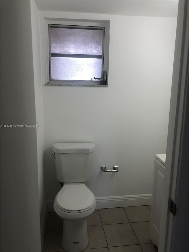 bathroom with tile flooring, vanity, and toilet