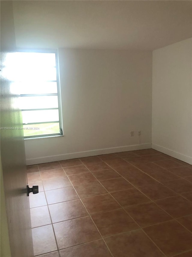 unfurnished room with tile floors