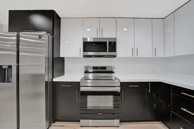 kitchen with white cabinetry, sink, light hardwood / wood-style flooring, and stainless steel appliances