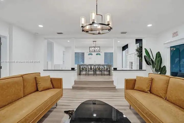 living room featuring an inviting chandelier and light wood-type flooring