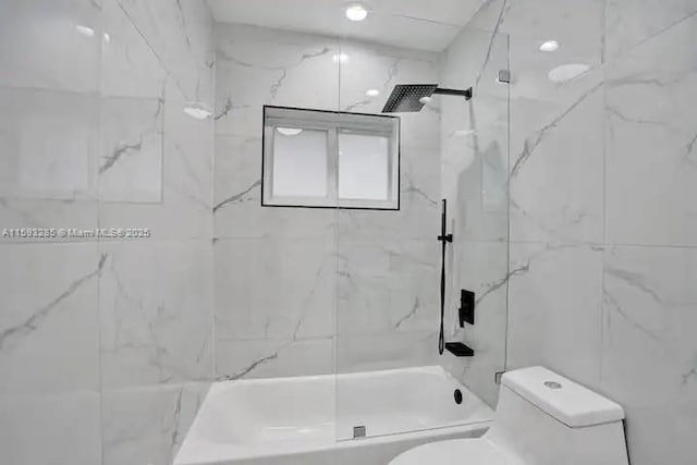 bathroom featuring tiled shower / bath combo and toilet