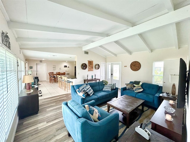 living room with vaulted ceiling with beams and light hardwood / wood-style flooring