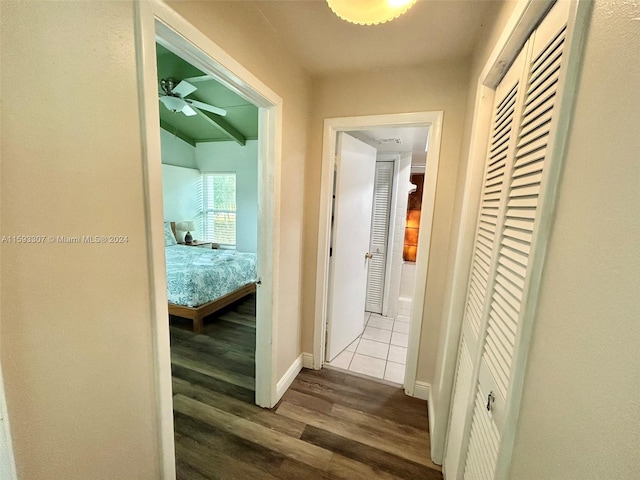 hallway with wood-type flooring and lofted ceiling