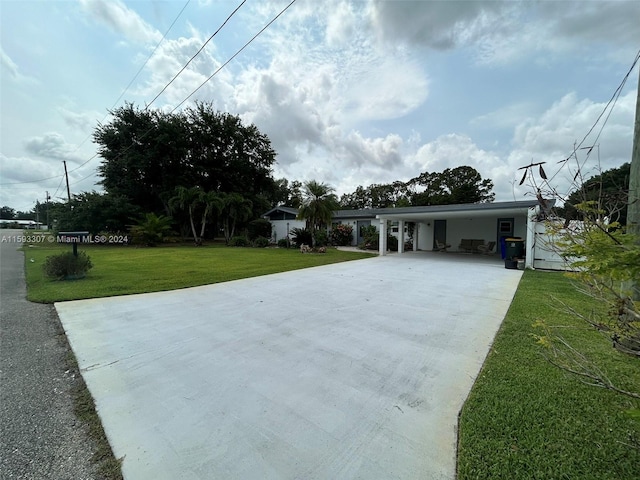 view of front of property with a front yard and a carport