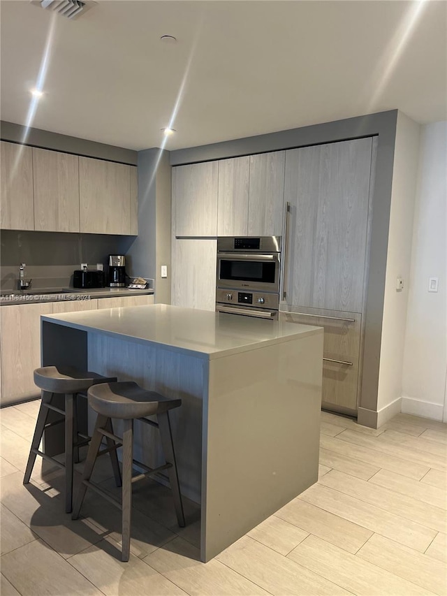 kitchen featuring a breakfast bar area, a center island, and double oven