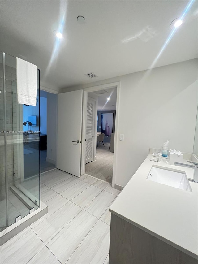 bathroom with tile patterned flooring, an enclosed shower, and vanity