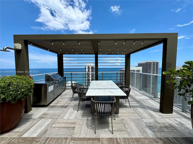 view of patio / terrace featuring a water view, an outdoor kitchen, and area for grilling