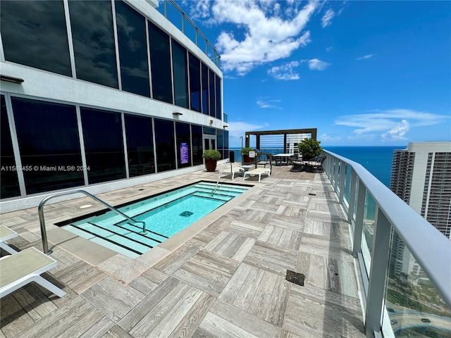 view of swimming pool featuring a patio, a community hot tub, and a water view