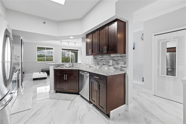 kitchen featuring kitchen peninsula, stainless steel appliances, light stone countertops, dark brown cabinets, and light tile floors