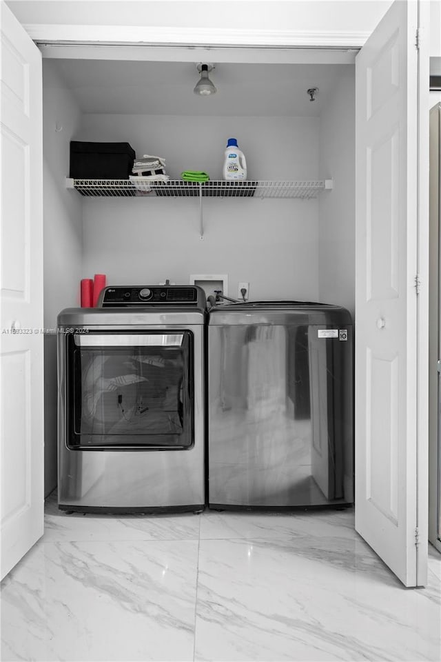 washroom featuring light tile flooring, hookup for a washing machine, and washing machine and dryer