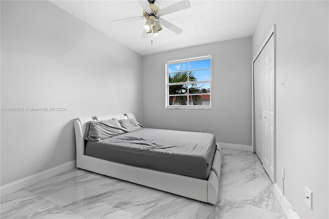 tiled bedroom with a textured ceiling, a closet, and ceiling fan