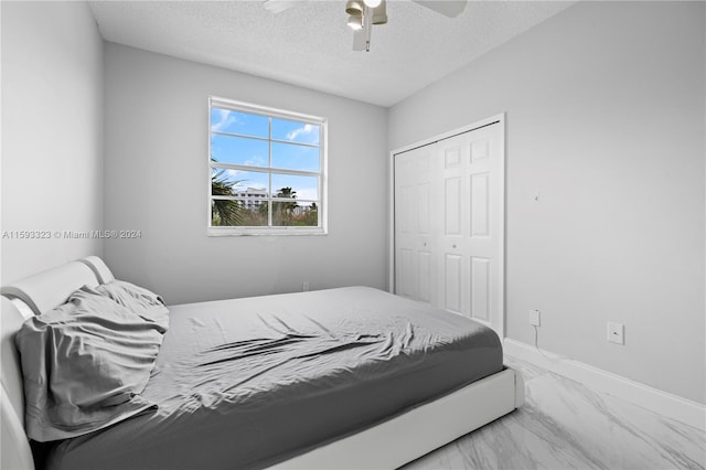 bedroom with ceiling fan, a closet, and a textured ceiling