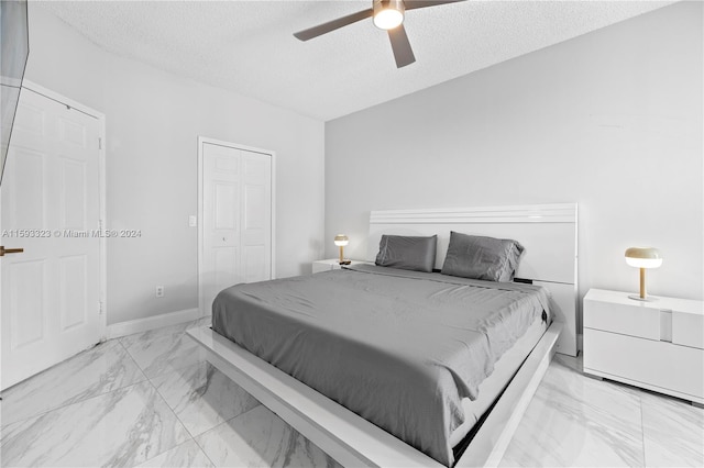 tiled bedroom featuring a closet, ceiling fan, and a textured ceiling