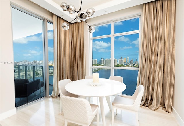 dining room featuring a notable chandelier and a water view