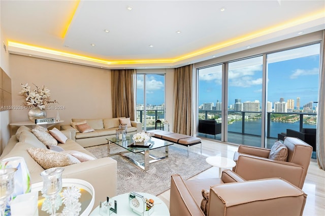 living room featuring plenty of natural light, floor to ceiling windows, and a water view