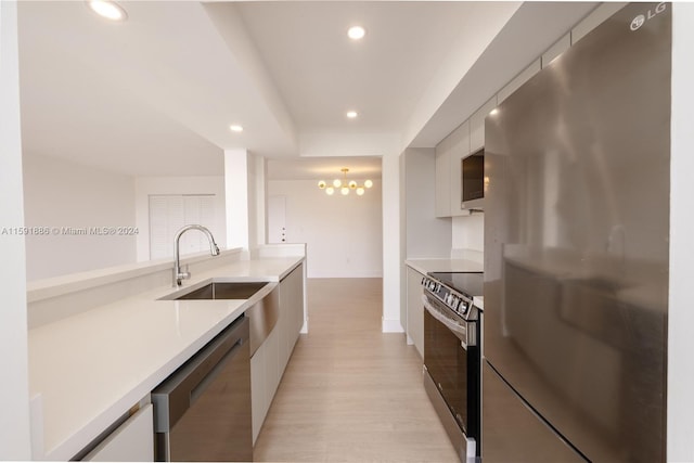 kitchen featuring white cabinetry, light hardwood / wood-style flooring, sink, and appliances with stainless steel finishes