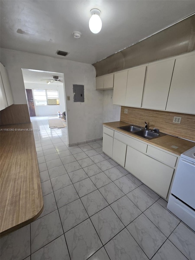 kitchen with electric panel, white cabinets, sink, ceiling fan, and white range