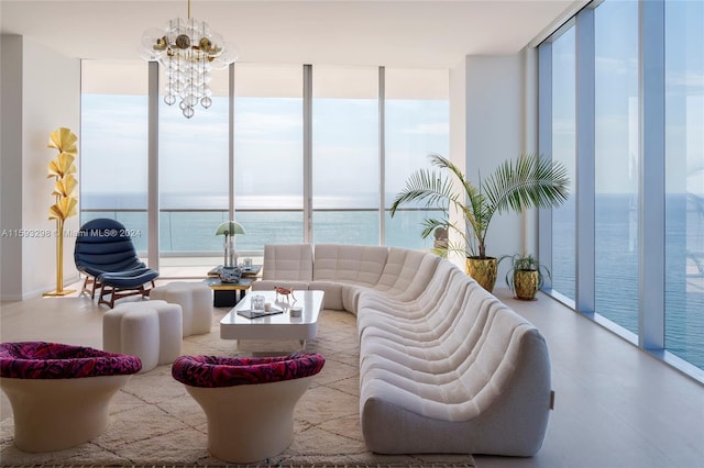 living room featuring a notable chandelier, a water view, and expansive windows