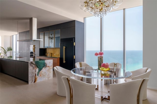 dining room with a notable chandelier, sink, and a water view