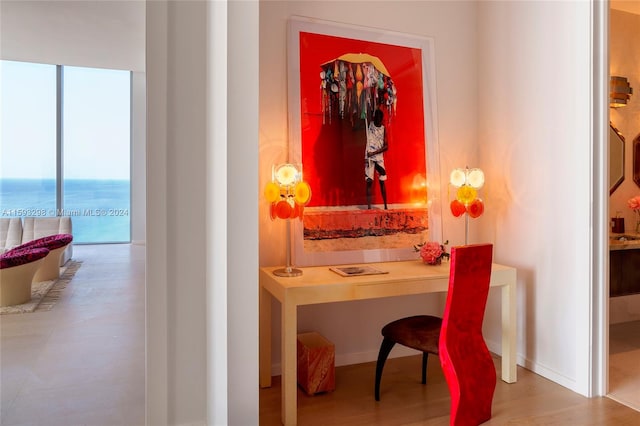 interior space featuring a water view, built in desk, and hardwood / wood-style floors