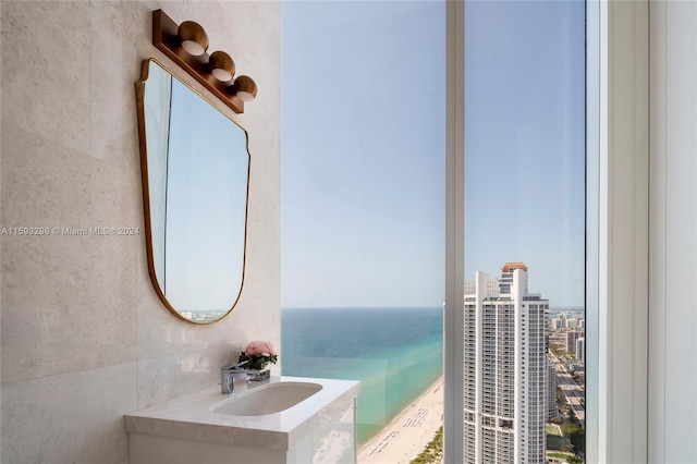 bathroom featuring a water view, sink, and tile walls