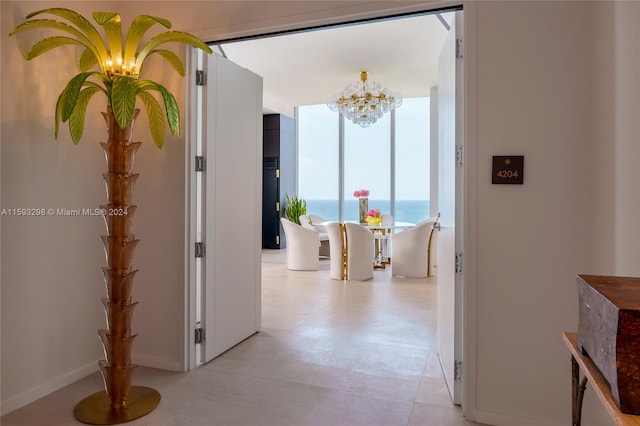 corridor with an inviting chandelier and a water view